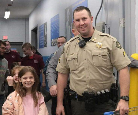 Matt Roberts with a kid at Shop with a Cop 2022