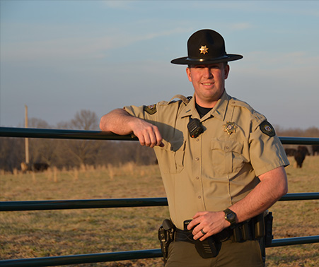 Matt Roberts standing against a fence