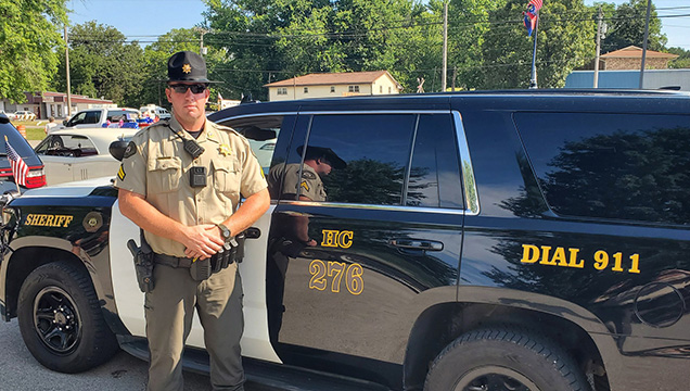 Matt Roberts standing in front of a Howell County Sheriff's Office patrol vehicle.